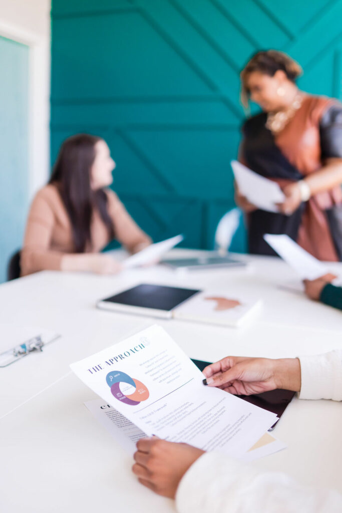 Women in a corporate environment discussing solutions and outcomes.